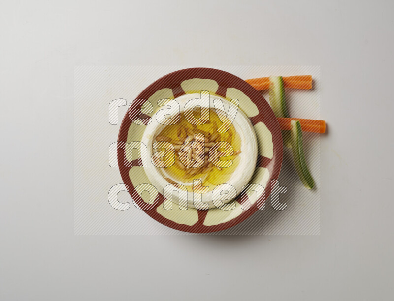 Lebnah garnished with pine nuts in a traditional plate on a white background