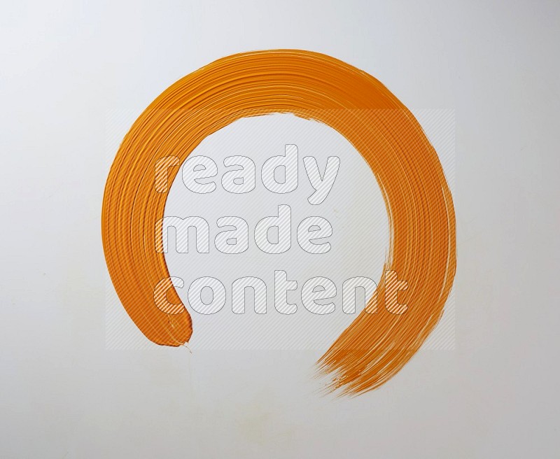 An orange circular painting brush stroke on white background