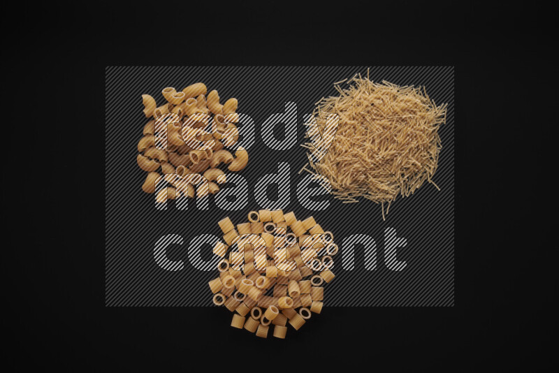 Different pasta types in bunches on black background