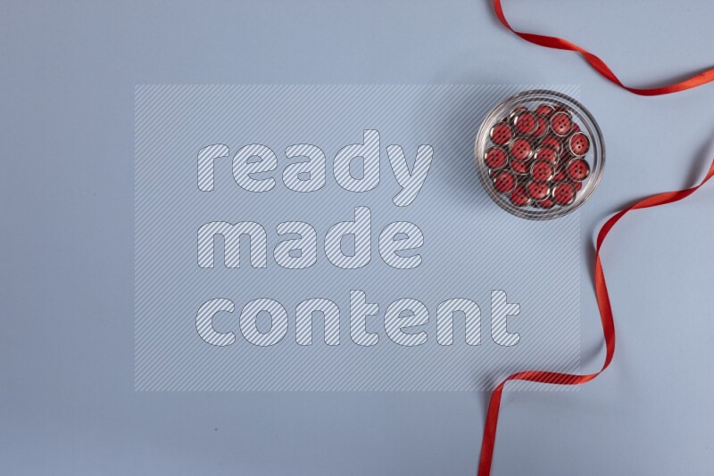 A red collection of sewing and tailoring tools arranged on a blue background