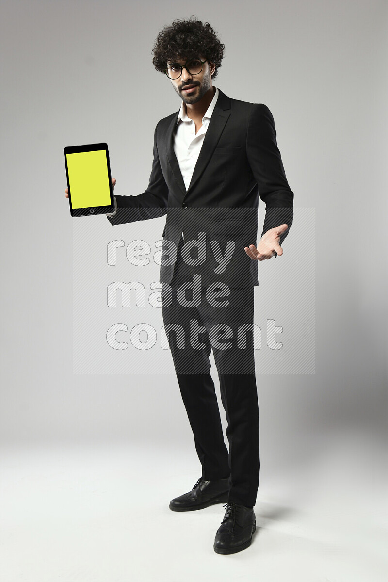 A man wearing formal standing and showing a tablet screen on white background