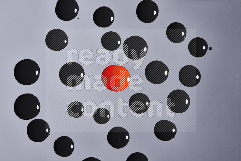 Close-ups of abstract red and black paint droplets on the surface