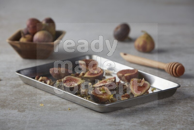 fresh figs on an oven tray on a textured grey background