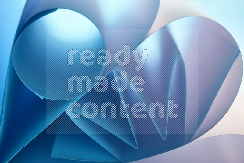 عرض فني لطيات الورق تخلق مزيج من الأشكال الهندسية، مضاءة بإضاءة ناعمة بدرجات اللون الأزرق والأبيض