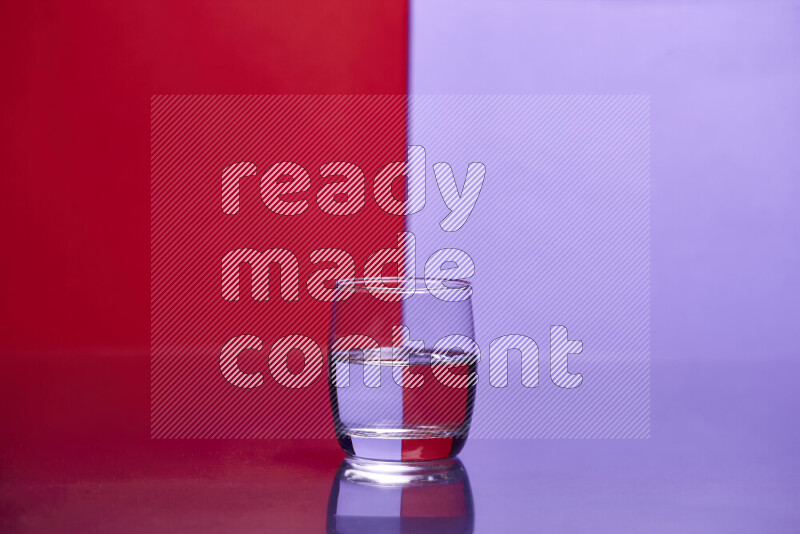 The image features a clear glassware filled with water, set against red and light purple background