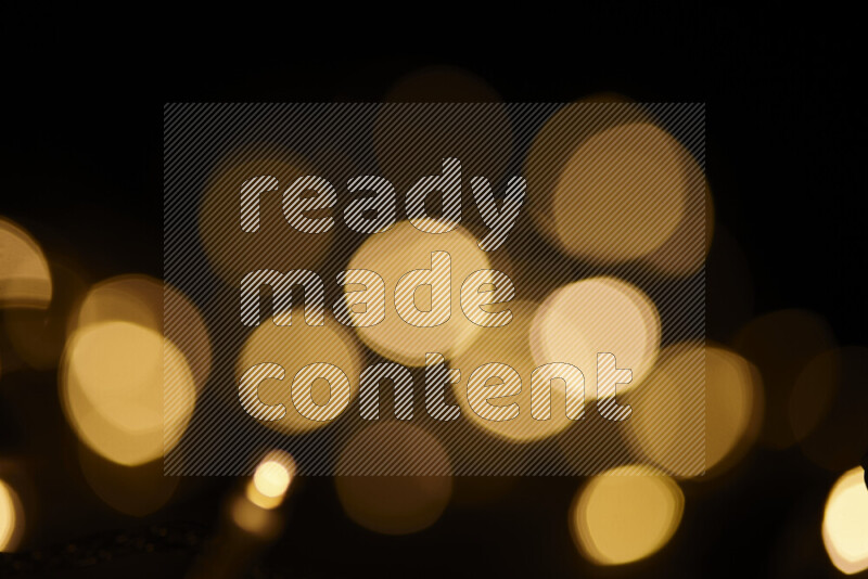 Light bulbs glowing against backdrop of golden bokeh