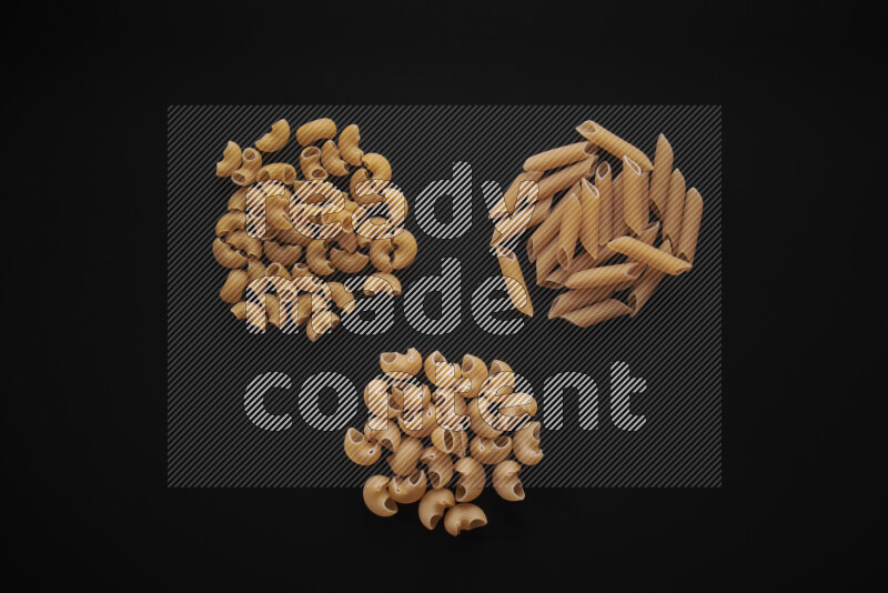 Different pasta types in bunches on black background