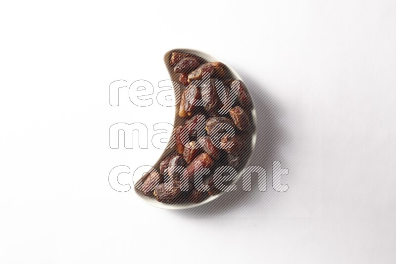 Dates in a crescent pottery plate on white background