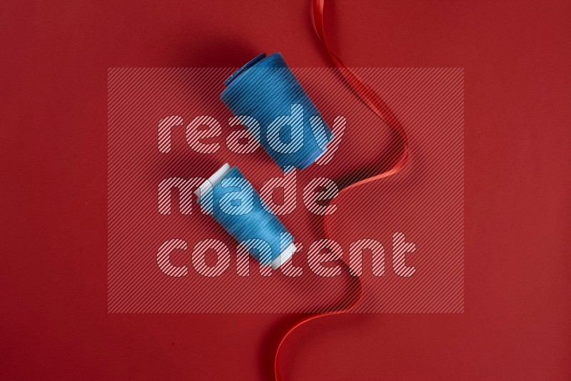 Blue sewing supplies on red background