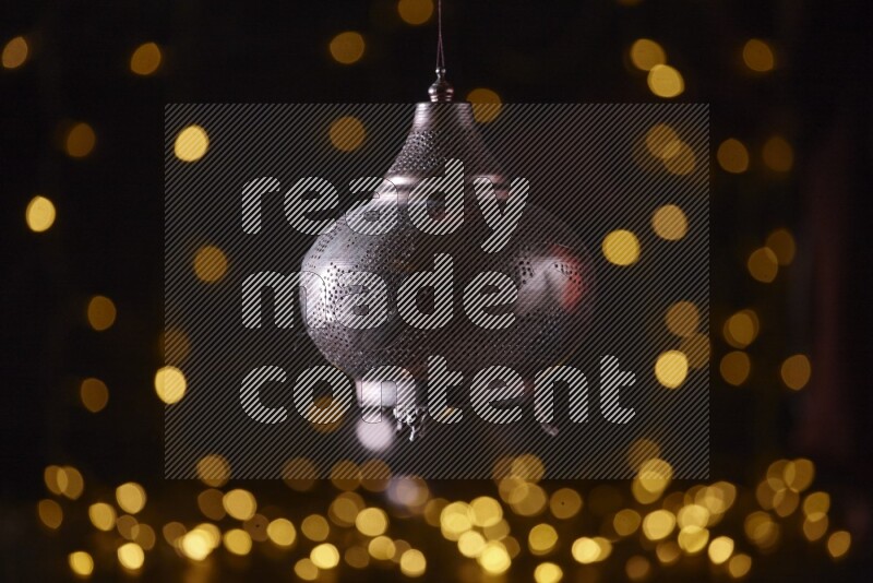 A traditional ramadan lantern surrounded by glowing fairy lights in a dark setup