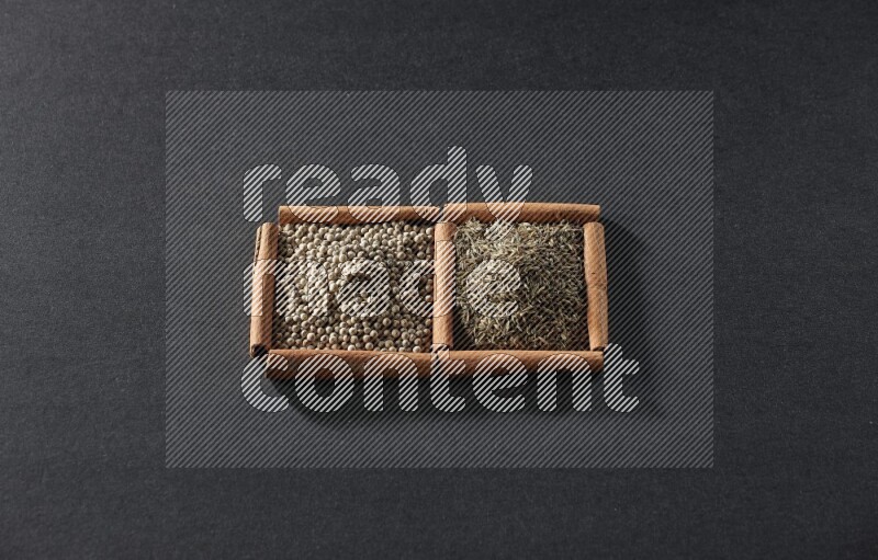 2 squares of cinnamon sticks full of white peppers and cumin on black flooring