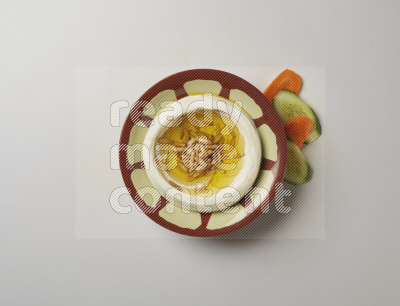 Lebnah garnished with pine nuts in a traditional plate on a white background