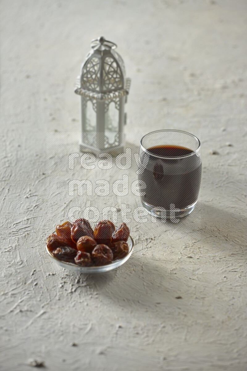 A white lantern with different drinks, dates, nuts, prayer beads and quran on white background