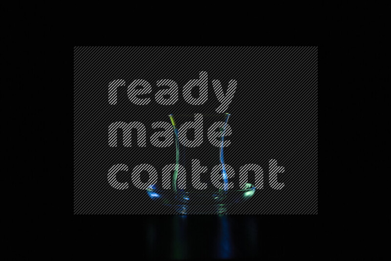 Glassware with rim light in blue and white against black background