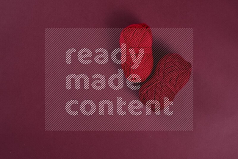 A red collection of sewing and tailoring tools arranged on a red background