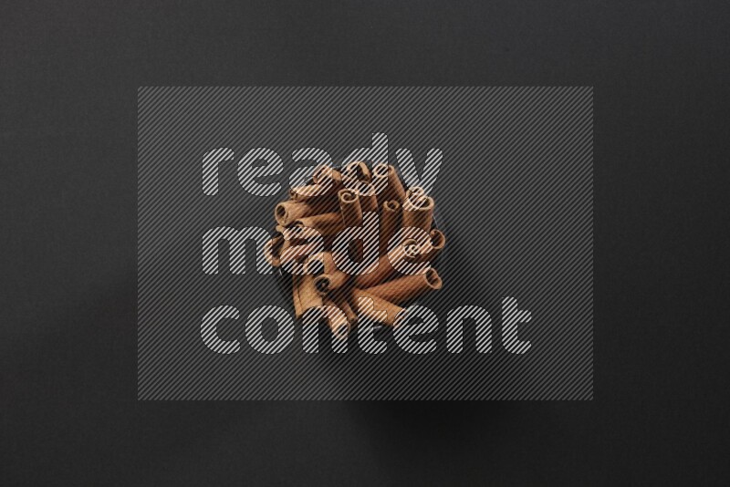 أعواد القرفة في وعاء فخاري أسود علي خلفية سوداء