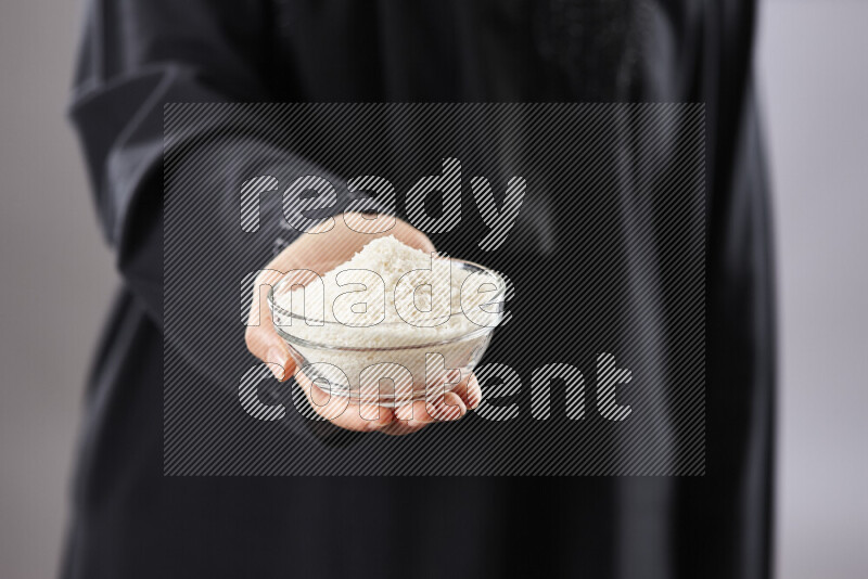 Woman in abaya holding different kinds of nuts in different positions