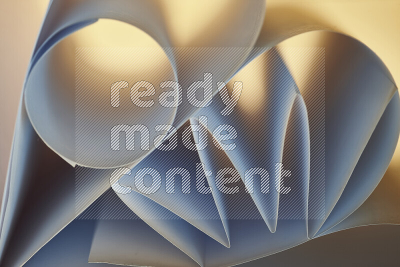 An artistic display of paper folds creating a harmonious blend of geometric shapes, highlighted by soft lighting in blue and warm tones