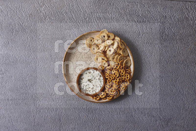 Assorted snacks in pottery bowls on grey background