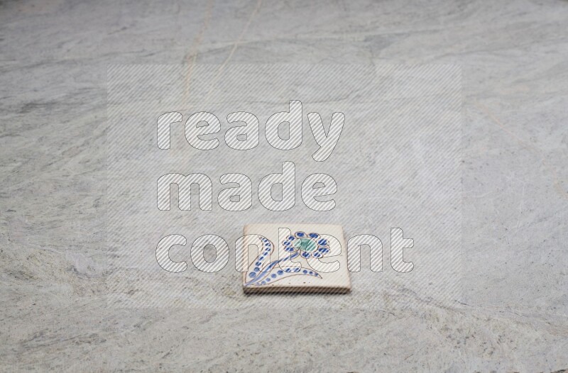 Top view shot of a pottery coaster\ tile on beige marble flooring