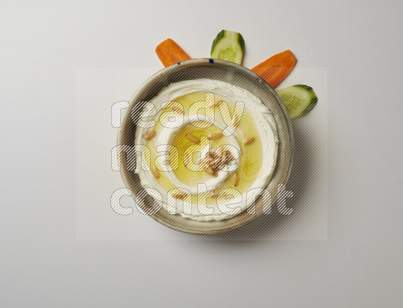 Lebnah garnished with pine nuts in a grey pottery plate on a white background