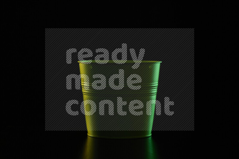 A plant pot with colored rim light against black background