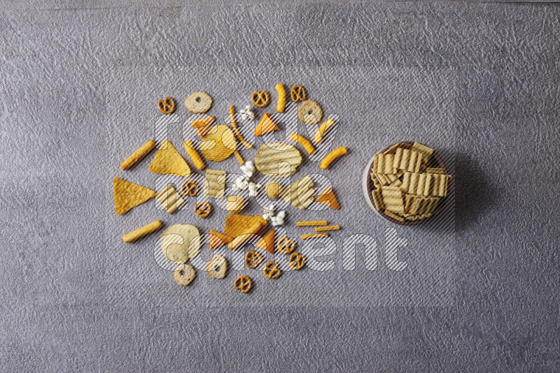 Assorted snacks in pottery bowls on grey background