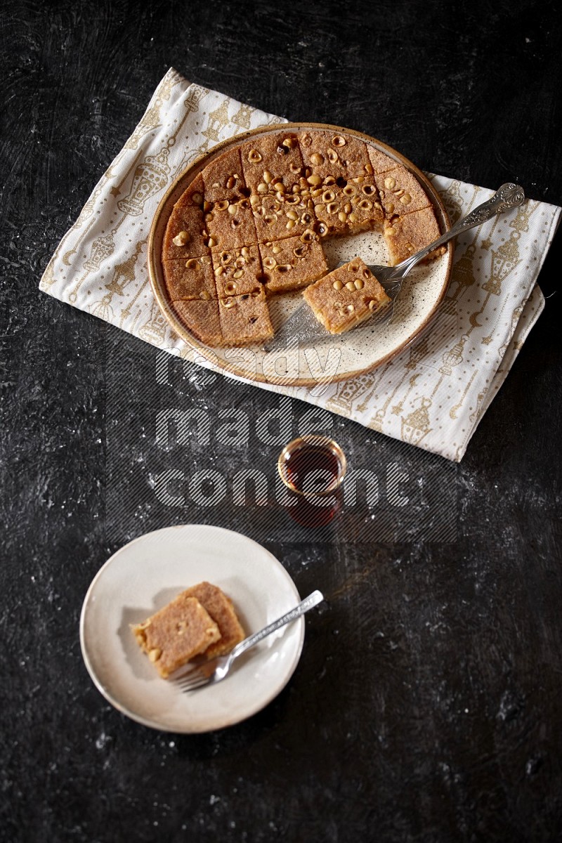 Basbousa with tea in a dark setup