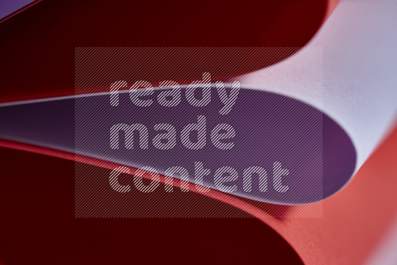 An abstract art showing purple and red paper sheets arranged in an overlapping curves
