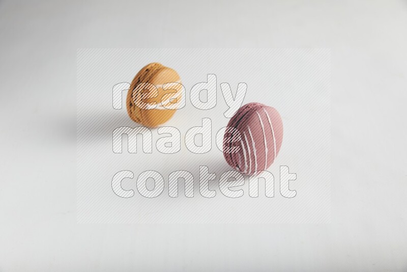 45º Shot of of two assorted Brown Irish Cream, and Red Poppy Flower macarons on white background