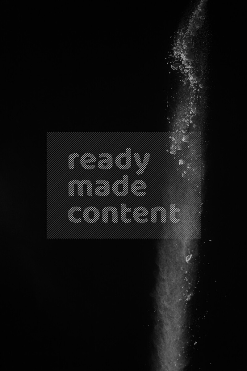 A side view of white powder explosion on black background