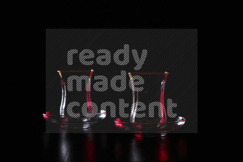 Glassware with rim light in red and green against black background