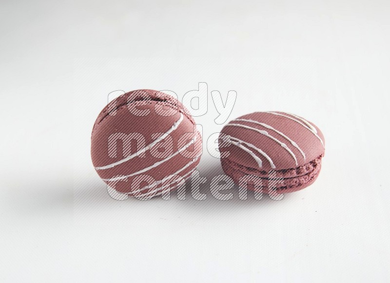 45º Shot of two Red Poppy Flower macarons on white background