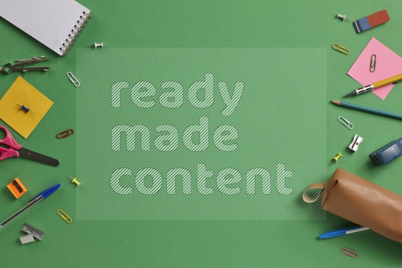 مستلزمات مدرسية مختلفة على خلفية خضراء