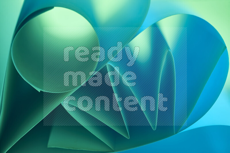 عرض فني لطيات الورق تخلق مزيج من الأشكال الهندسية، مضاءة بإضاءة ناعمة بدرجات اللون الأخضر والأزرق