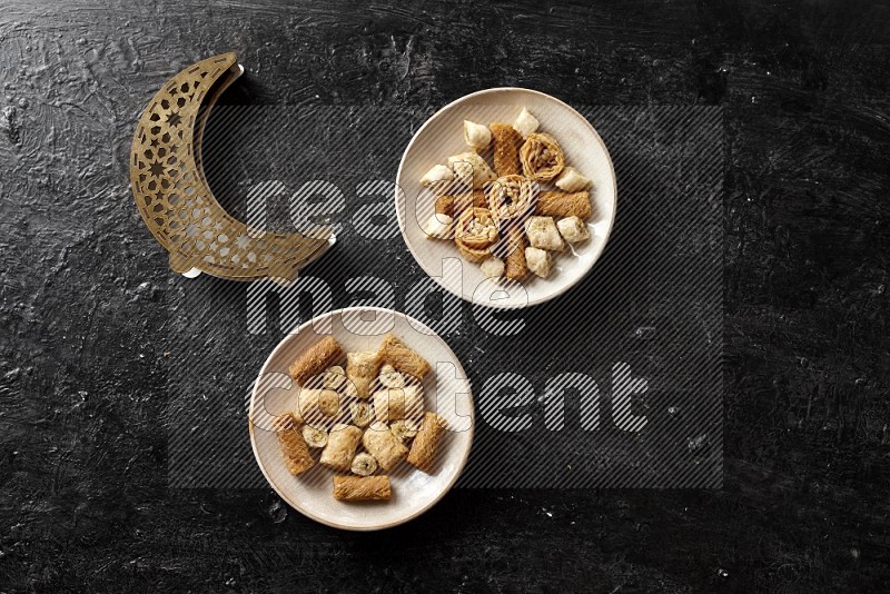 Oriental sweets in pottery plates with a lantern in a dark setup