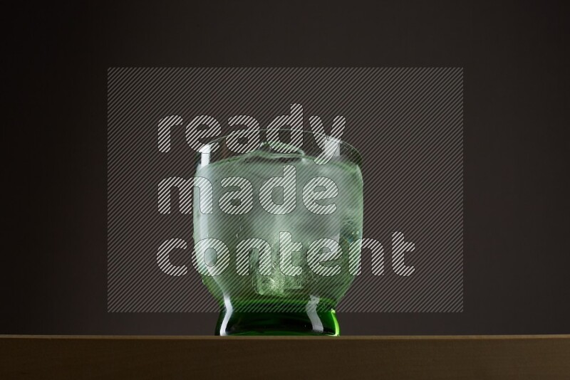 Low angle shot of a glass of water and ice on grey background