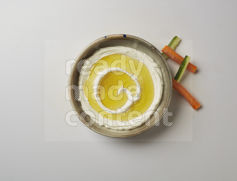 Lebnah garnished with olive oil in a grey pottery plate on a white background