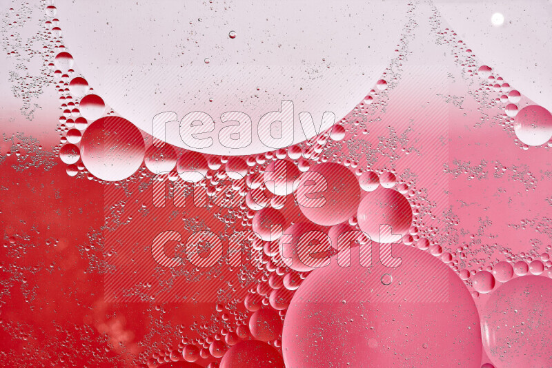 Close-ups of abstract oil bubbles on water surface in shades of white, red and pink