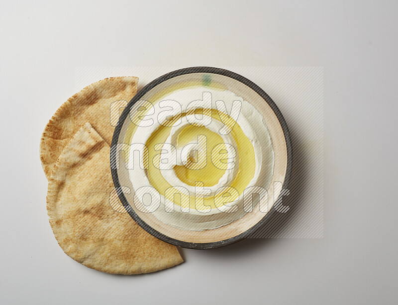 Lebnah garnished with olive oil in a pottery plate on a white background