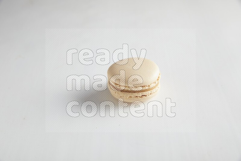 45º Shot of White Caramel fleur de sel macaron on white background