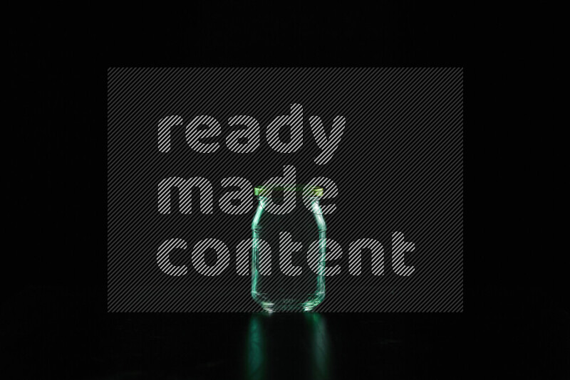 Glassware with rim light in green against black background