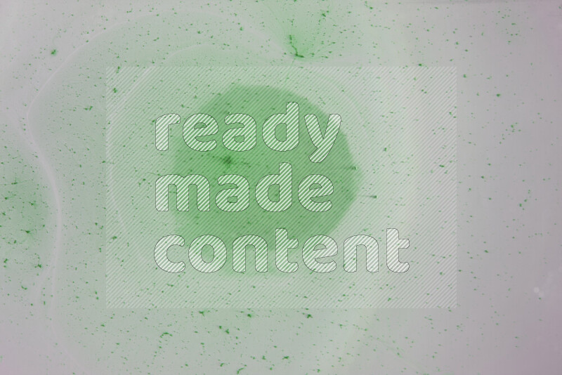 The image captures a dramatic splatter of green paint over a white backdrop