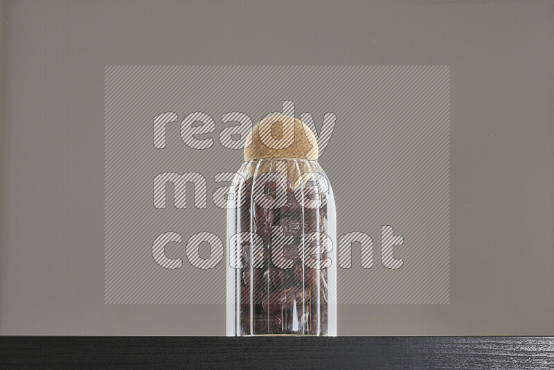 Dates in a glass jar on black background