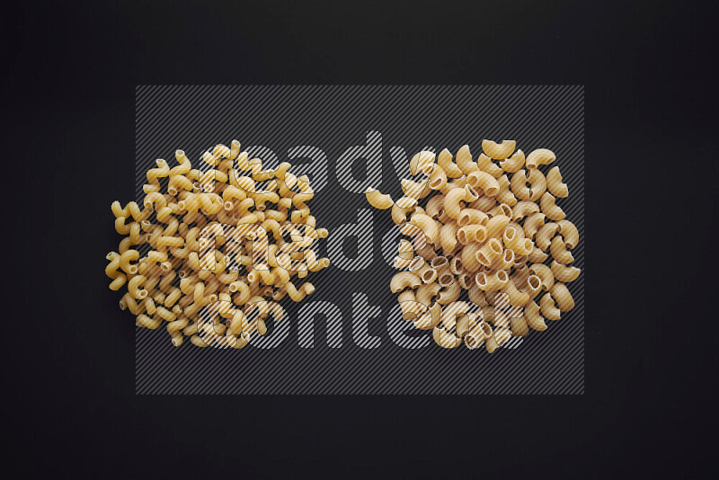 Different pasta types in bunches on black background