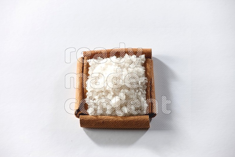 A single square of cinnamon sticks full of salt on white flooring