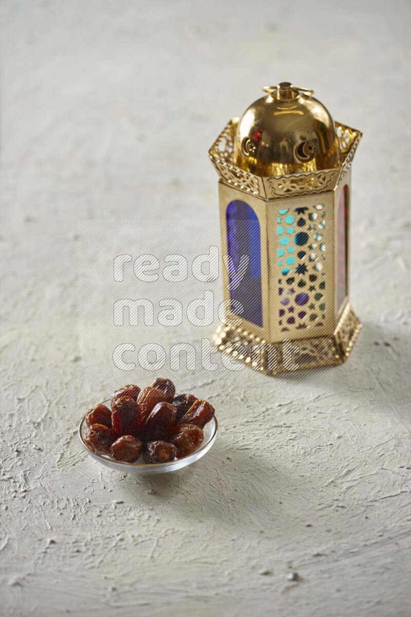 A golden lantern with different drinks, dates, nuts, prayer beads and quran on textured white background