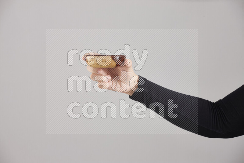 A woman in black abaya holding different wooden essentials in different positions