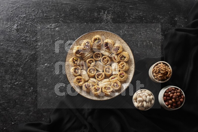 Oriental sweets in pottery plates with nuts in a dark setup