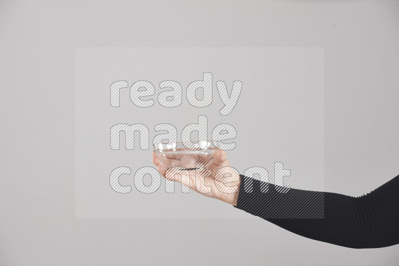 A woman in black abaya holding different glassware in different positions